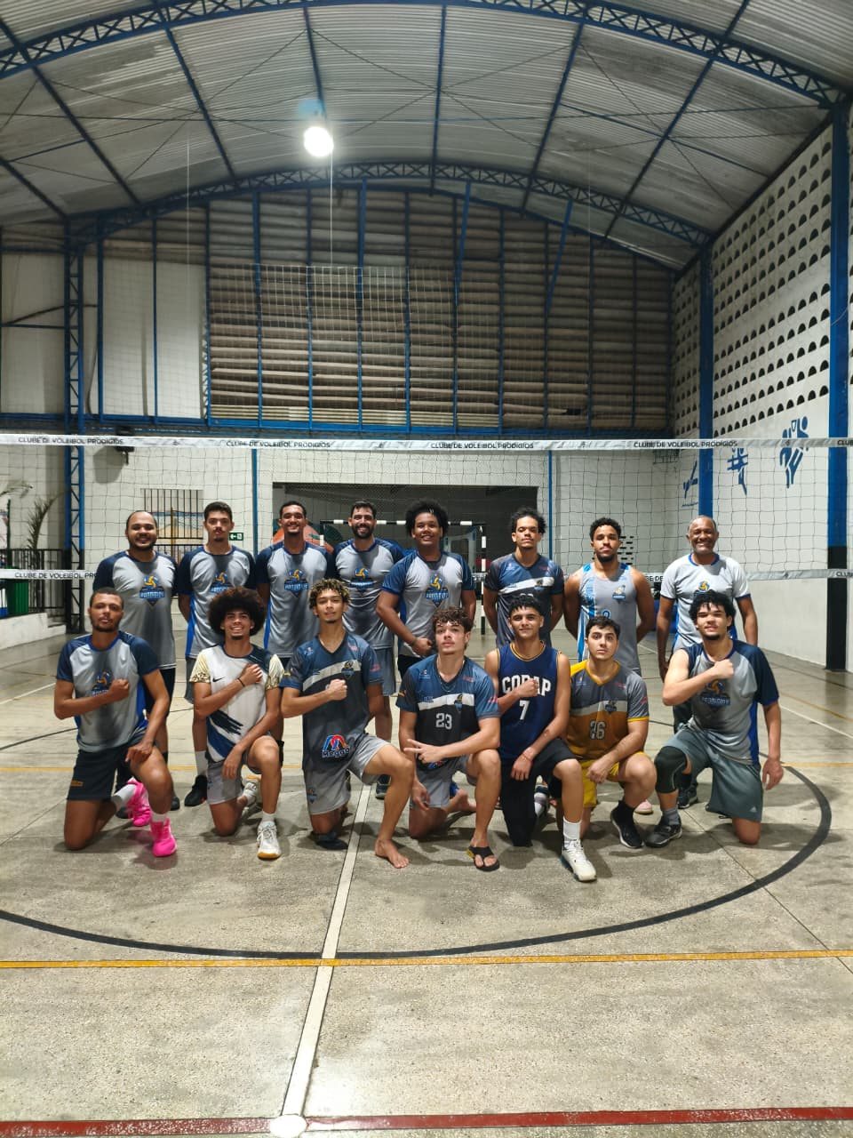 Grupo de atletas do Prodígios reunido em frente ao mural do clube