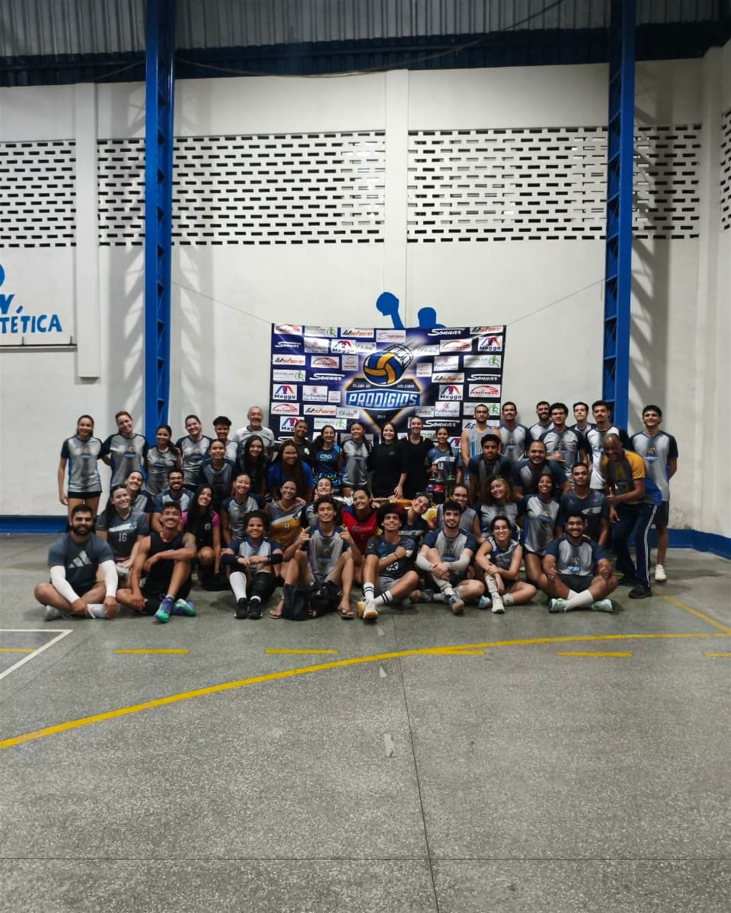 Elenco completo do Prodígios reunido em frente ao painel do clube