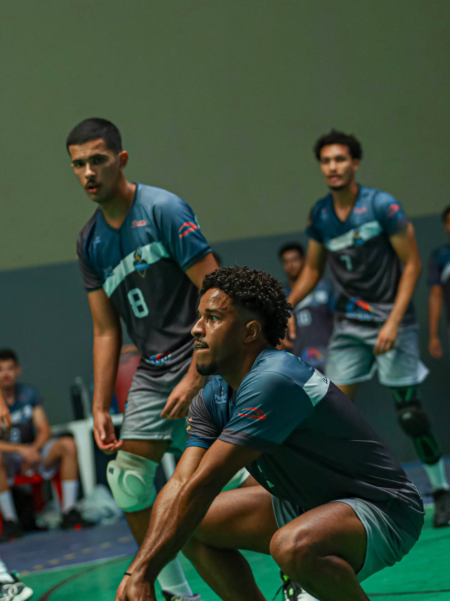 Três jogadores do Prodígios agachados em posição de defesa, esperando o ataque adversário