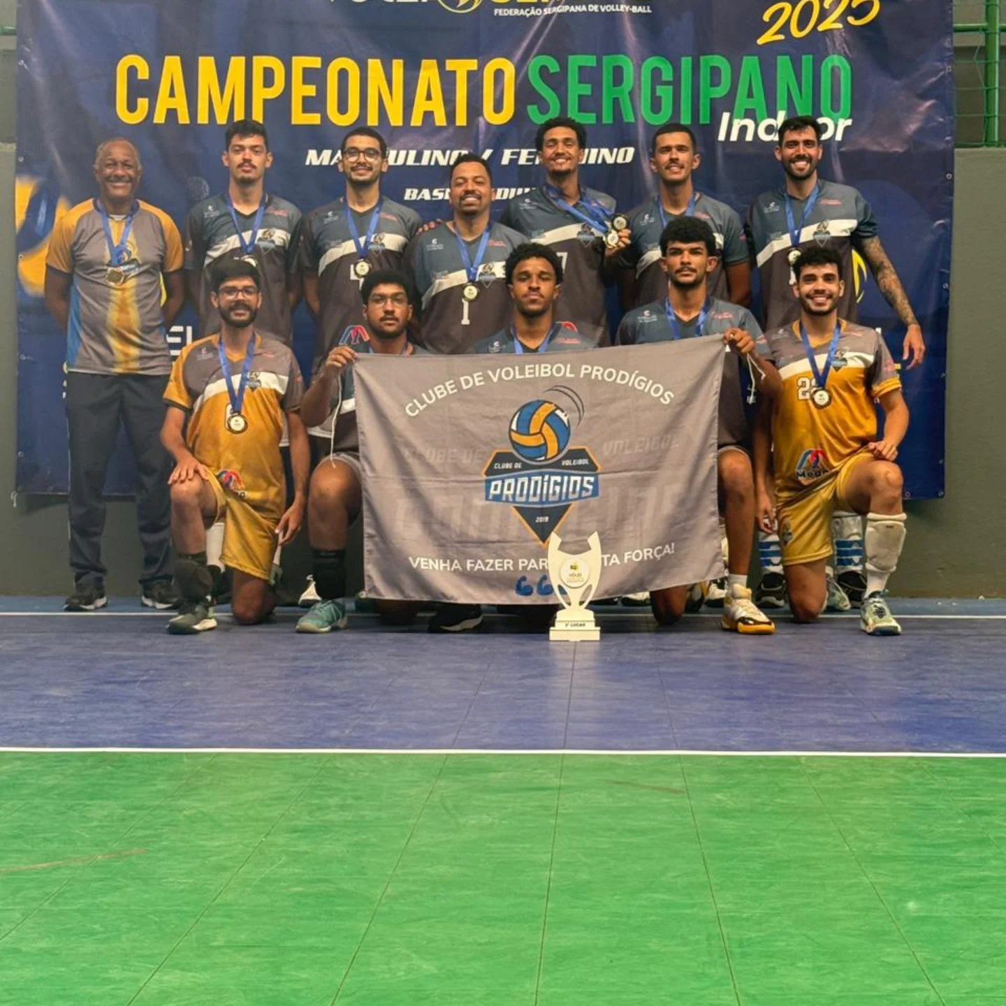 Equipe masculina do Prodígios com a bandeira do clube, medalhas e troféu no Campeonato Sergipano Indoor 2025