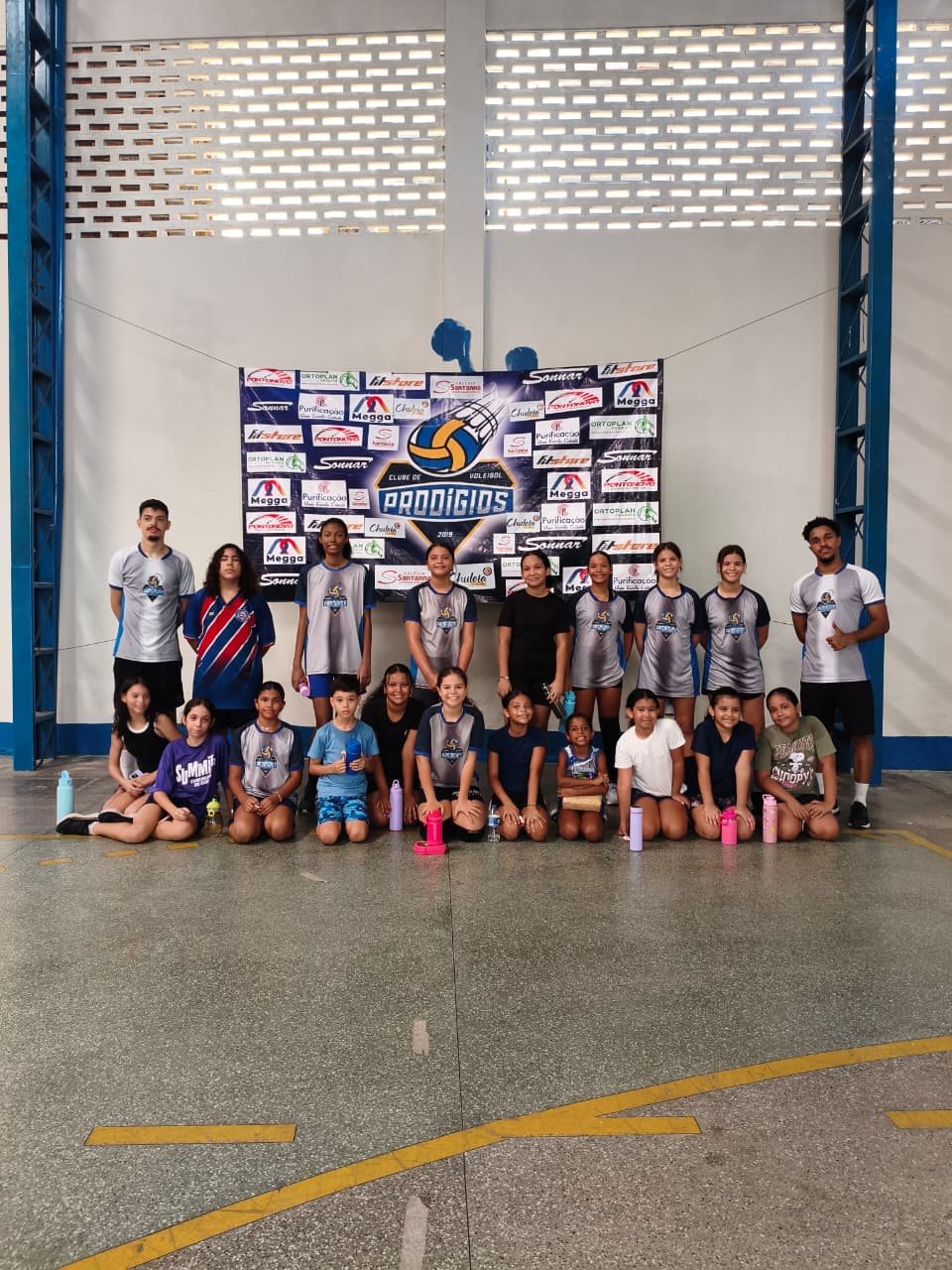 Turma da escolinha do Prodígios reunida em frente ao mural do clube