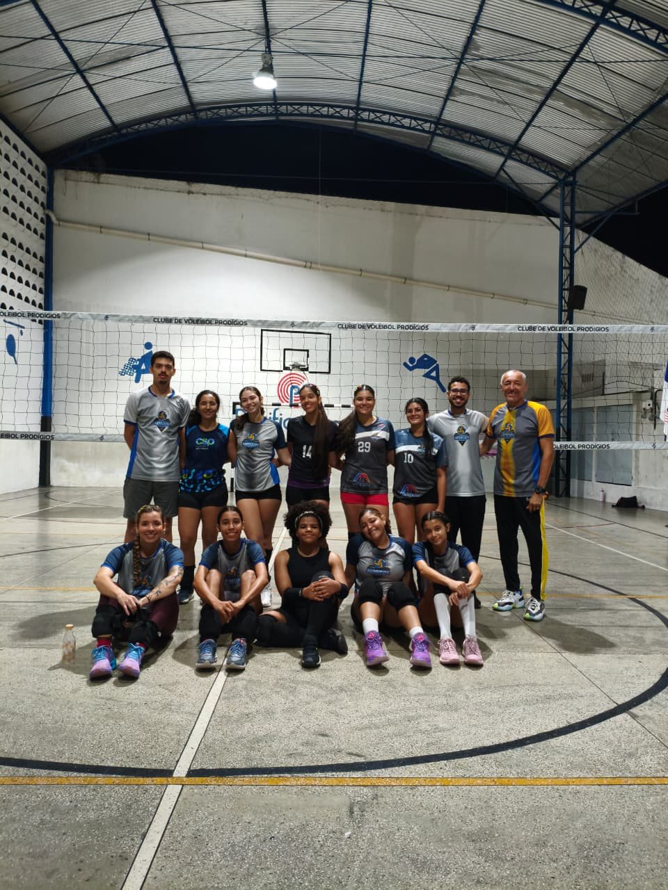 Grupo de atletas do Prodígios reunido em frente ao mural do clube