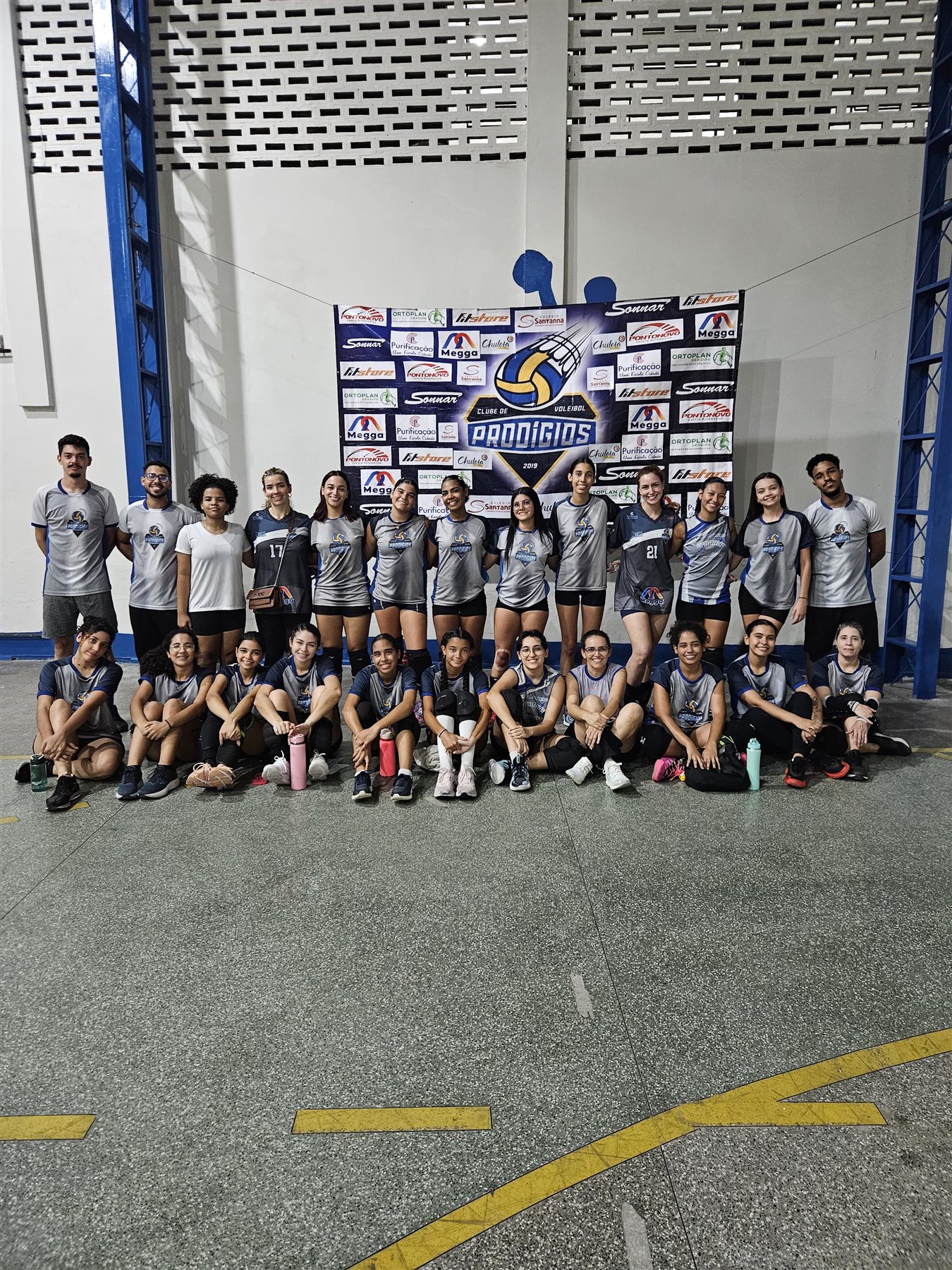 Equipe feminina do Prodígios reunida em frente ao mural do clube